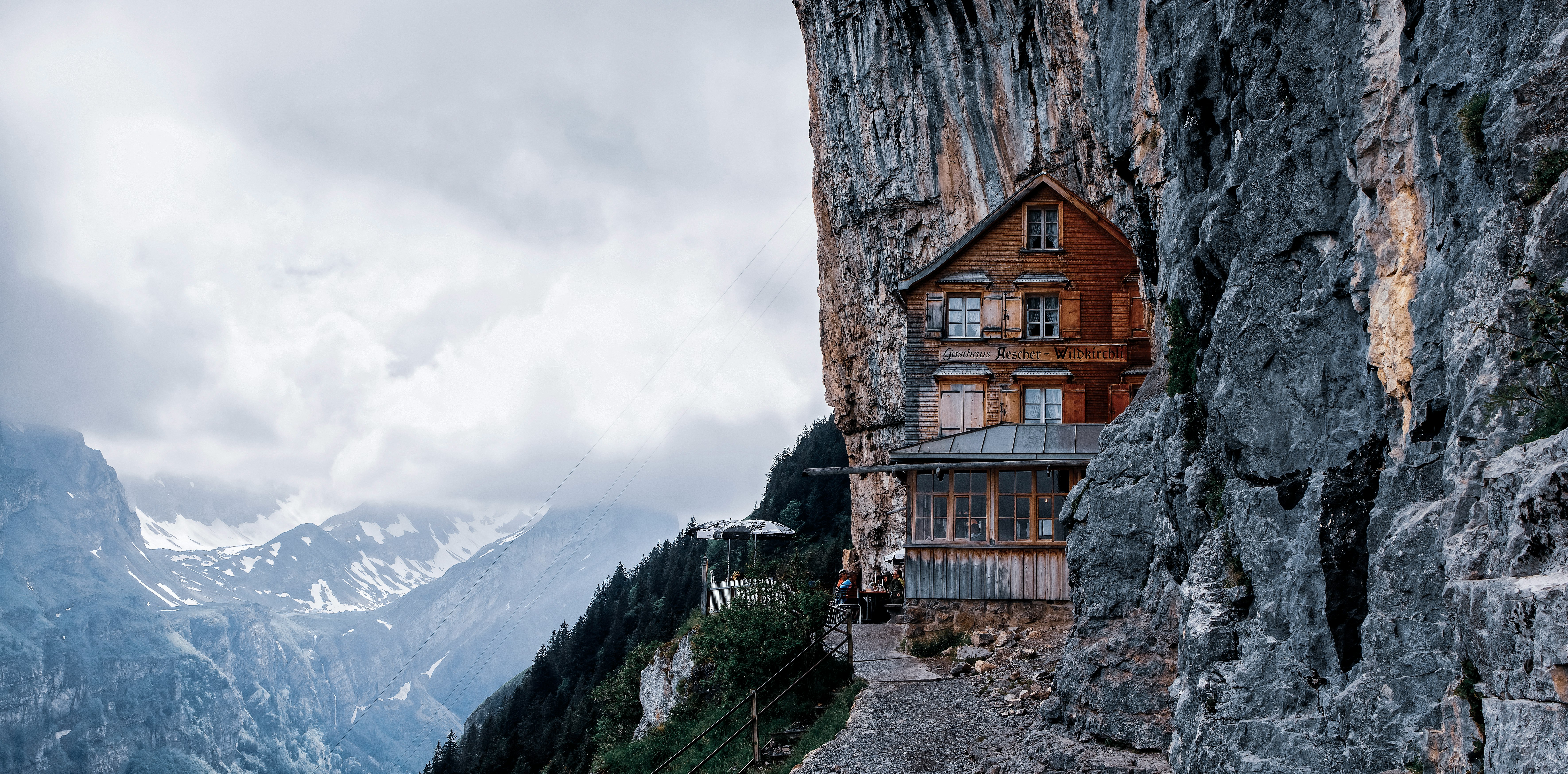 brown wooden house near mountain during daytime